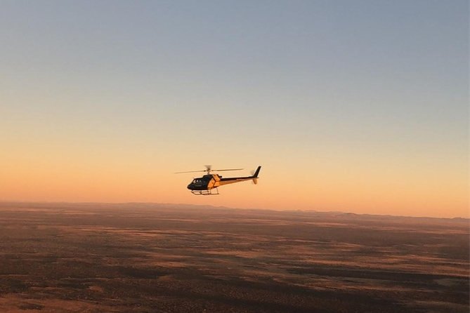 A helicopter crossing the plain at the end of the day