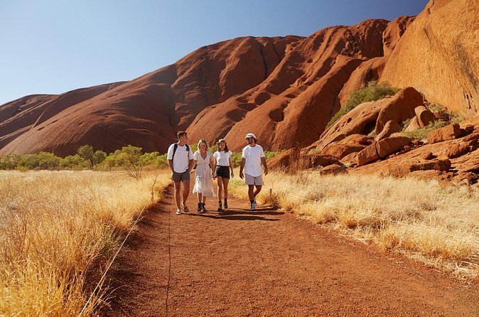 A red sand path running beneath the curved flank of a dome