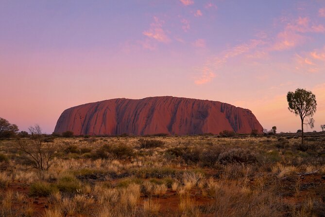 Uluru under a pink dusk sky after the sun has gone
