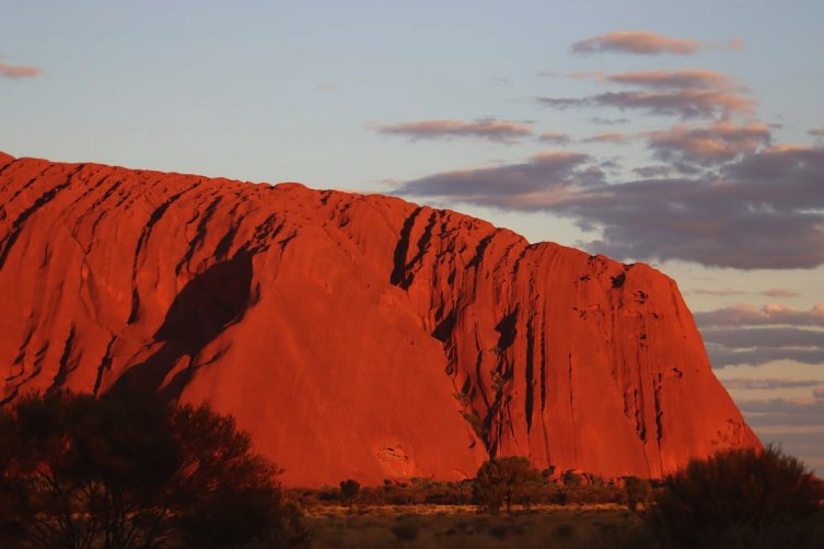 Uluru glowing at sunset seen from the viewing area